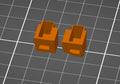 Digitale CAD Vorschau von zwei orangen PS4 Smarttrigger 3D Modellen auf grauem Gitterhintergrund