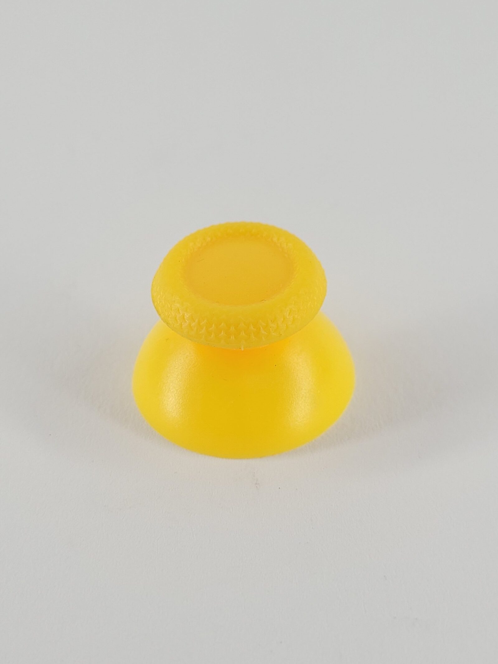 Gelber PS5 Analogstick mit strukturierter Kappe und glatter Basis