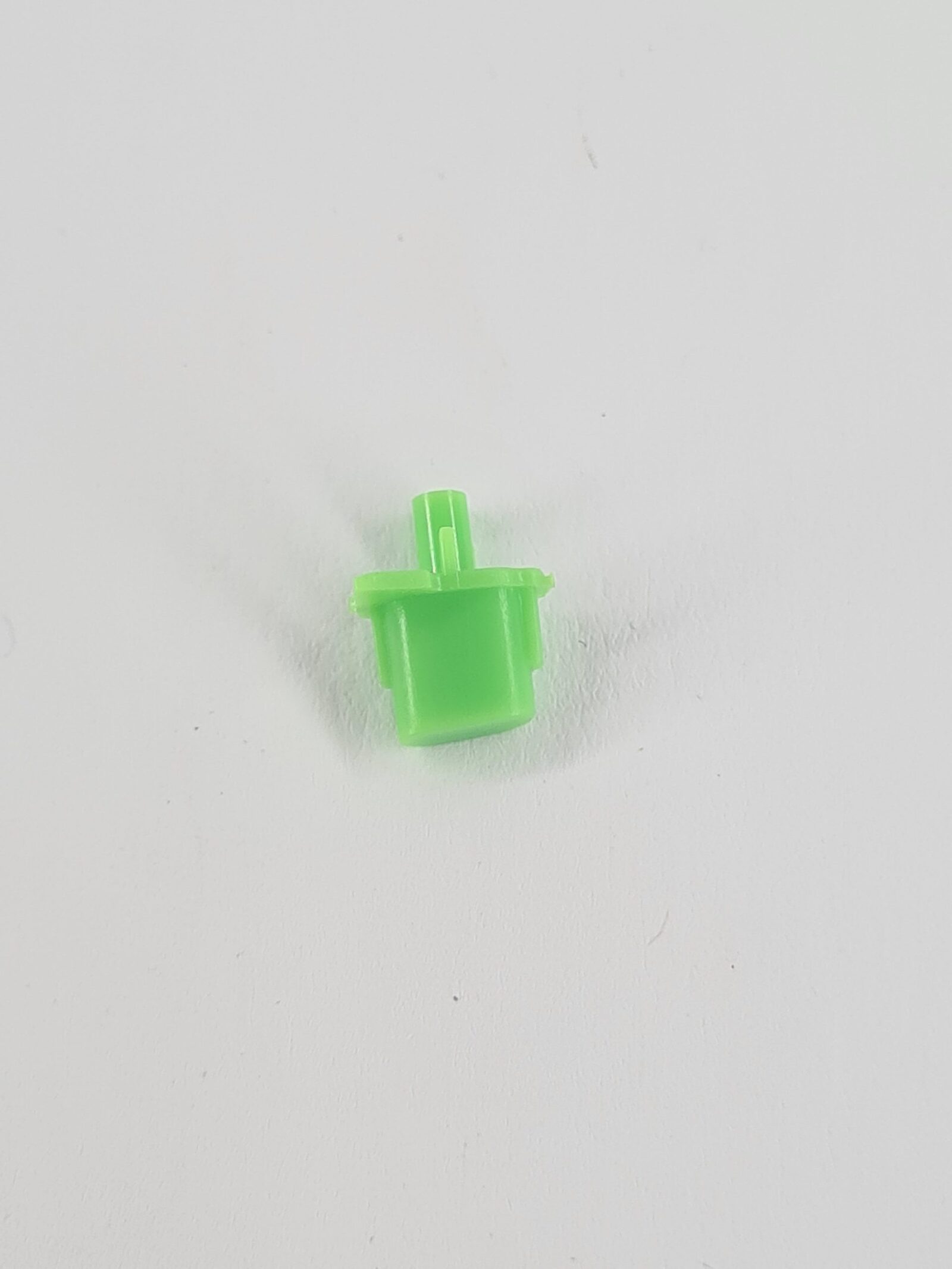 Grüne PS5 Share Taste aus Kunststoff mit zylindrischem Stift