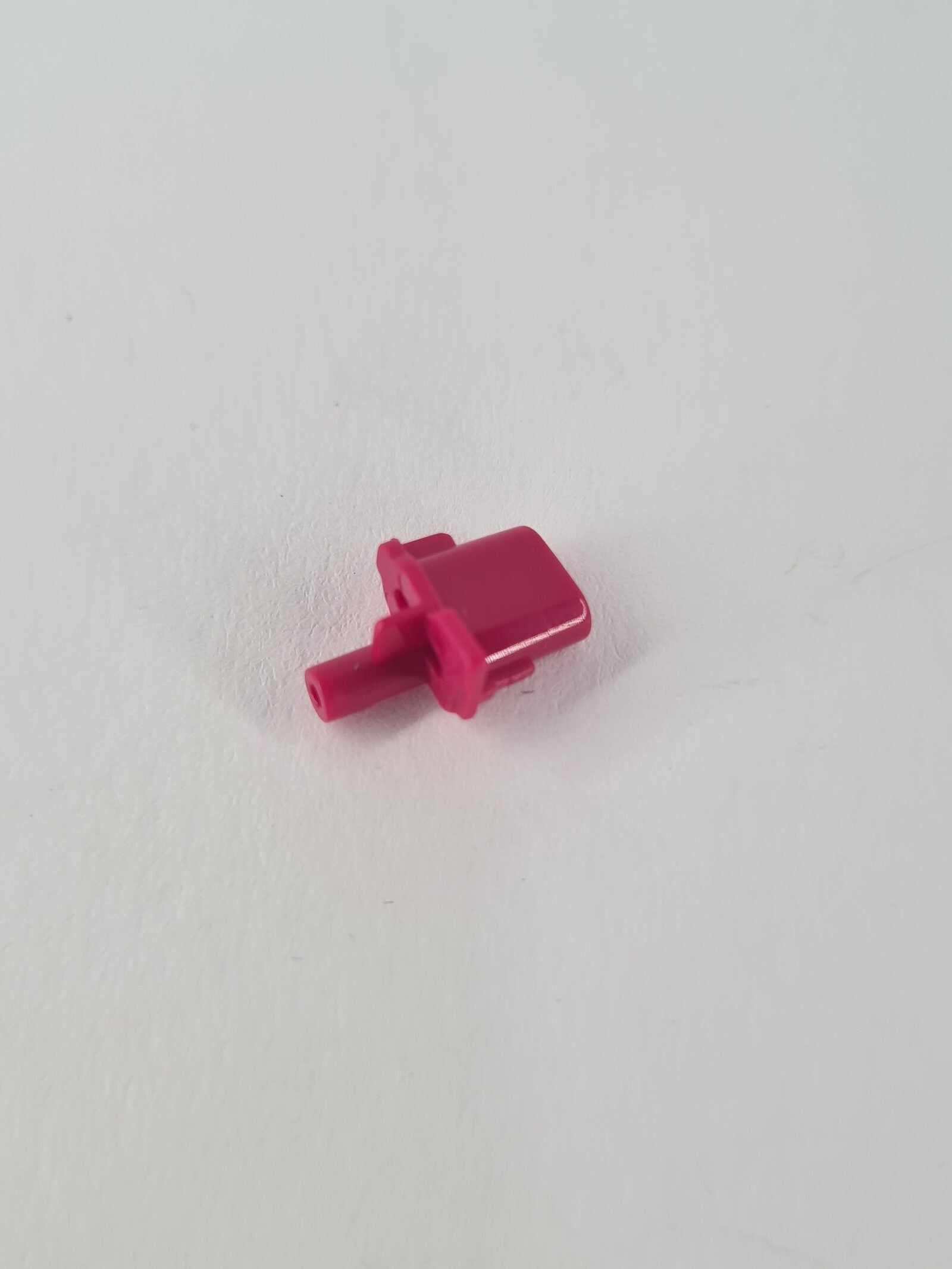 Pink-rote PS5 Share Taste aus Kunststoff mit zylindrischem Stift und Haltenasen