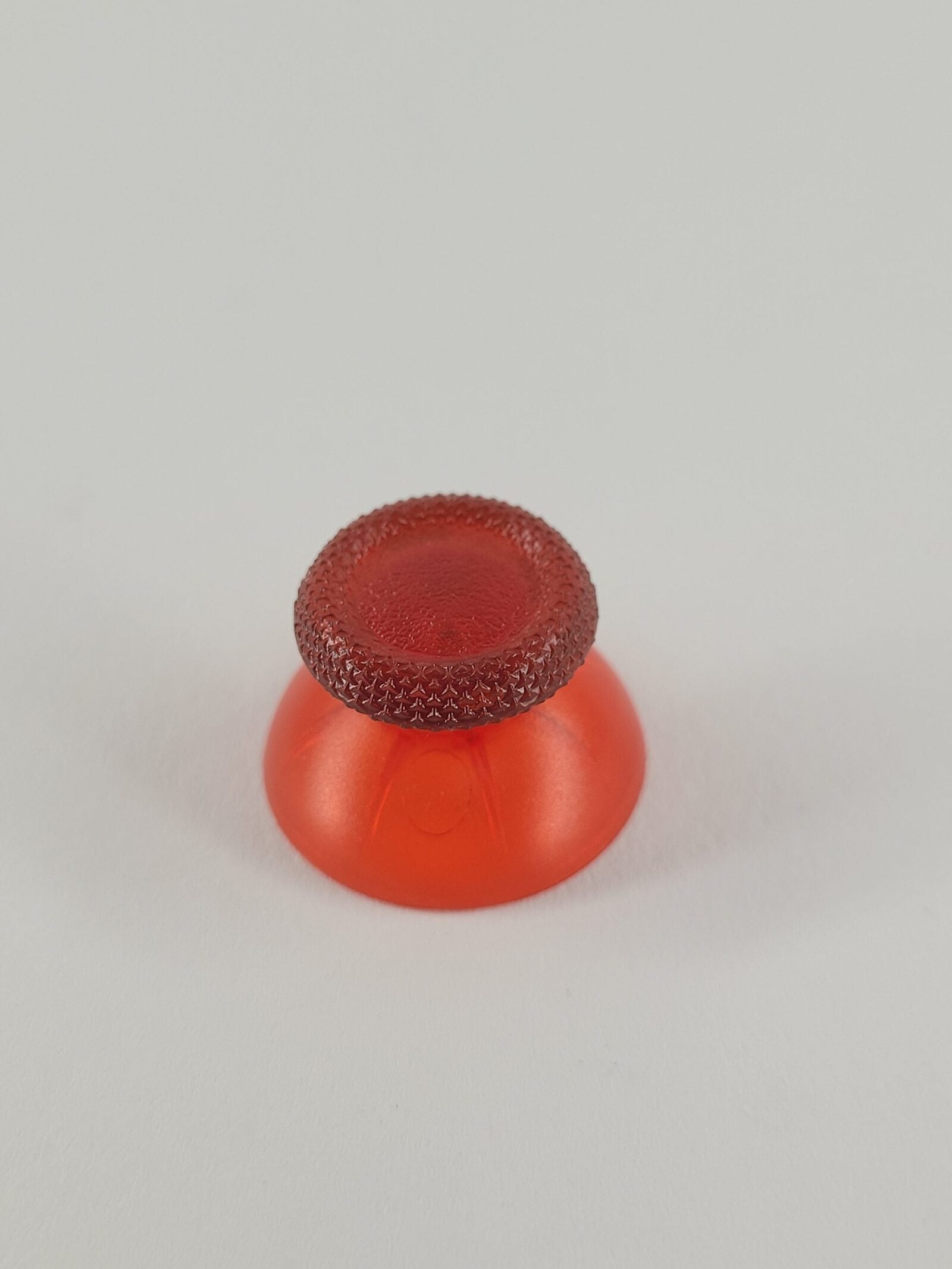 Roter transparenter Analogstick mit geriffeltem Rand und glockenförmigem Sockel