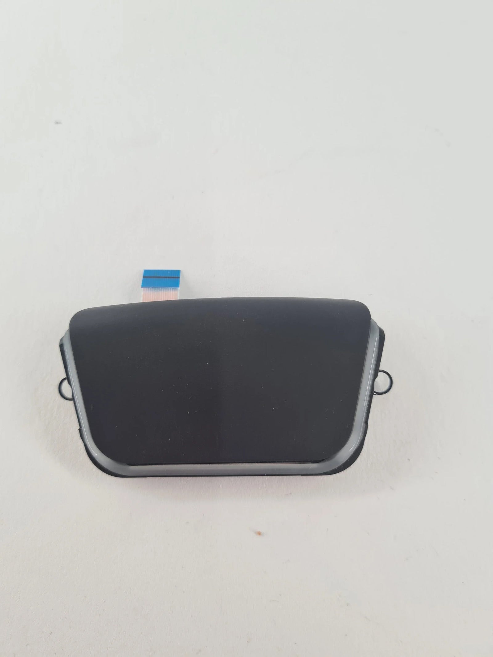 Schwarzes PS5 Touchpad Modul mit Flachbandkabel und Metallbügeln auf weißem Untergrund